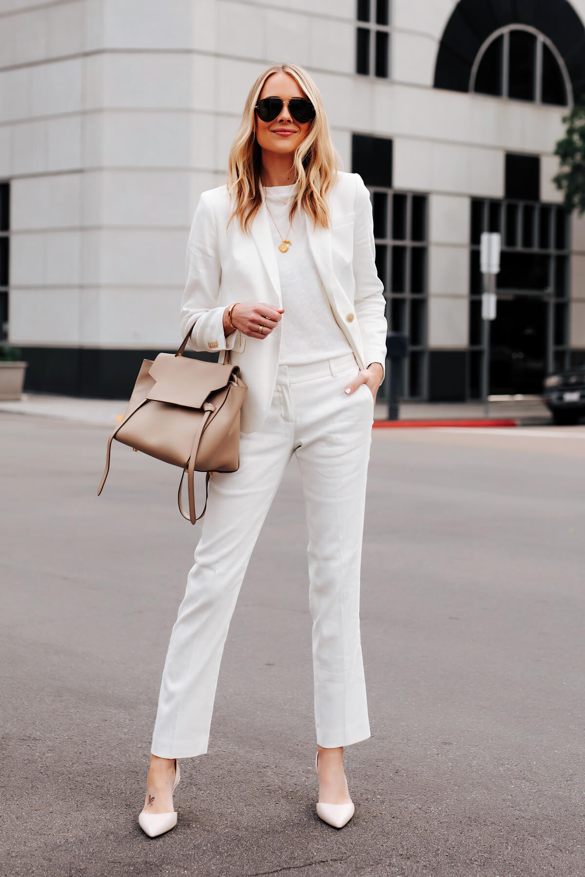 Fashionable woman wearing trendy outfit with yellow sunglasses, leather  backpack, pink blazer, wide leg white trousers, walking in street of city.  Full-length outdoor portrait Photos | Adobe Stock